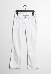 Jeans de mezclilla blanca colgados en una percha negra, con un diseño de pierna recta, bolsillos frontales y el logotipo bordado "Hilfiger Denim" en la cinturilla.