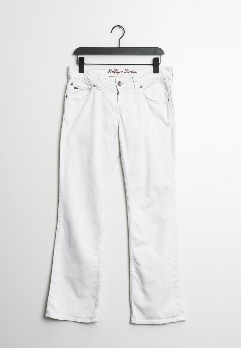 Jeans de mezclilla blanca colgados en una percha negra, con un diseño de pierna recta, bolsillos frontales y el logotipo bordado "Hilfiger Denim" en la cinturilla.