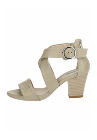 Sandali beige con tacco alto, dotati di cinturini incrociati, fibbia regolabile e un tacco quadrato texturizzato. Materiale in pelle liscia con cuciture sottili.