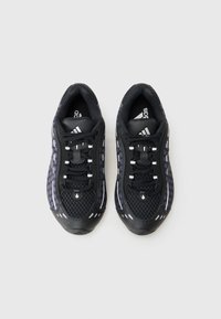 Black athletic shoes with a mesh upper, reflective accents, and a textured rubber sole. Features laces and a padded collar for comfort.