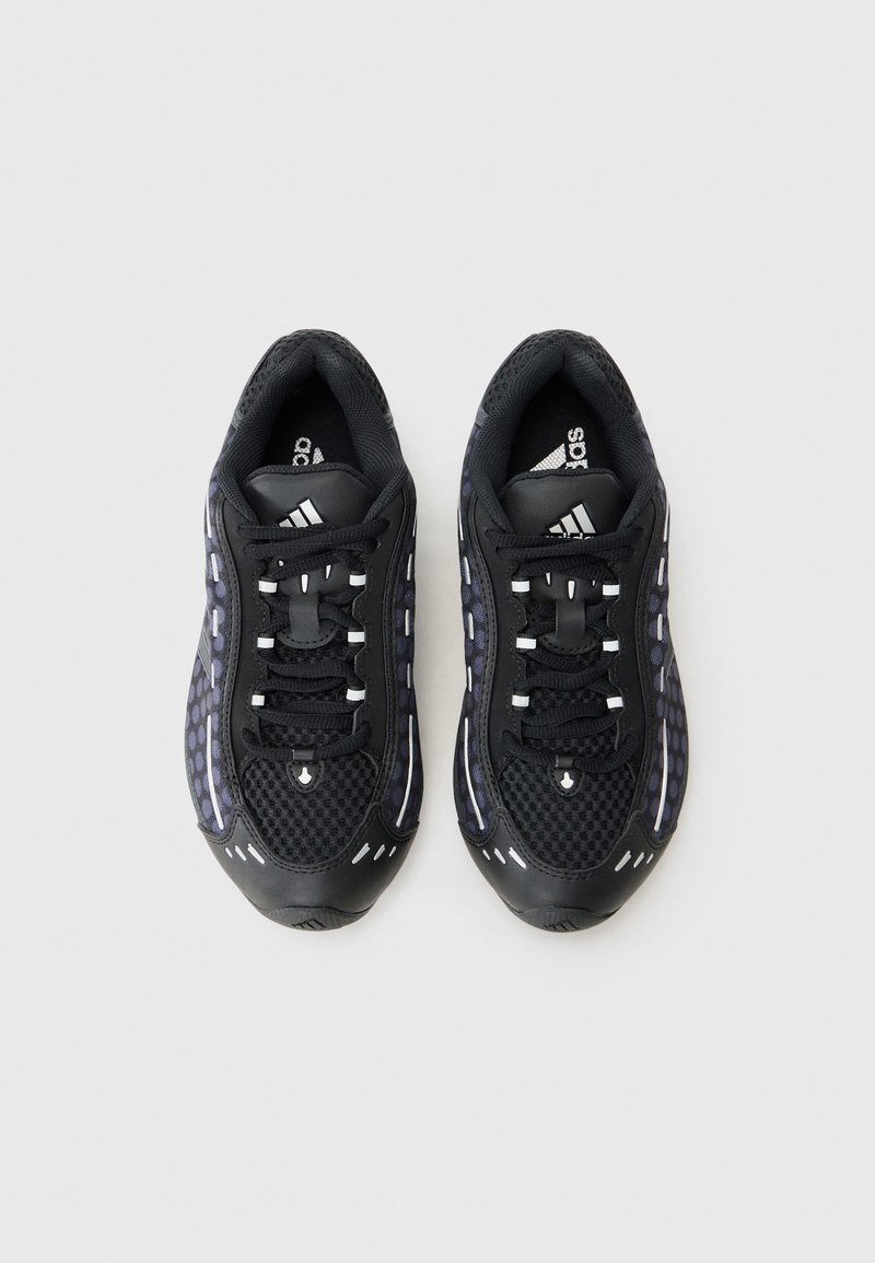 Zapatillas deportivas negras con parte superior de malla, acentos reflectantes y suela de goma texturizada. Cuentan con cordones y un collar acolchado para mayor comodidad.