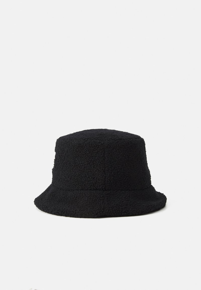 Chapeau seau en polaire noir avec une surface douce et texturée et un bord incliné vers le bas sur fond blanc uni.