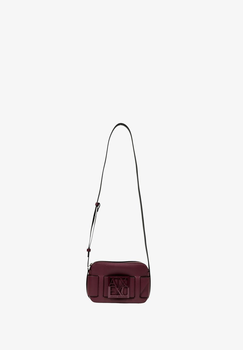 Borsa a tracolla bordeaux con cinturino nero, caratterizzata da una superficie testurizzata, chiusura con zip e dettaglio del logo in rilievo sul fronte.