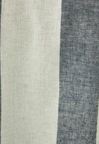 Tessuto di lino con strisce alternate di beige chiaro e blu navy scuro. La texture è leggermente ruvida e traspirante.