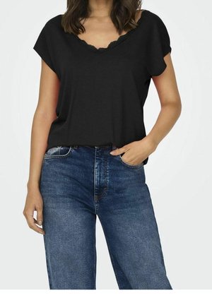 Sort V-hals top med blondekant, korte ærmer, parret med højttaljede blå denim jeans. Tæt, men afslappet design.