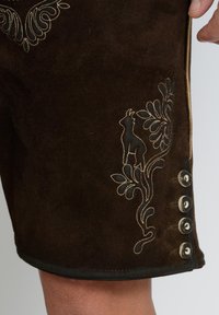 Ruske sametne kratke hlače s cvetličnimi in živalskimi vezeninami v krem in črni barvi. Vključujejo dekorativne gumbe ob strani.