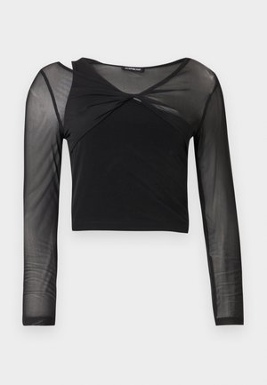 Haut court noir à manches longues avec un empiècement en maille transparente sur le haut de la poitrine, les épaules et les manches, doté d'un détail torsadé à l'avant du col.