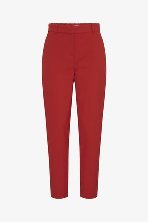 Punased kitseneva lõikega püksid vööaasade ja peidetud esikinnitusega, pahkluumõõdus, puhta ja hästitehtud disainiga.