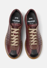 Bordeauxrote und schwarze Lederschuhe mit beigen Schnürsenkeln, beschriftet mit "Camper Pelotas", ausgestattet mit einer Gummisohle und stilvollen Nähten.