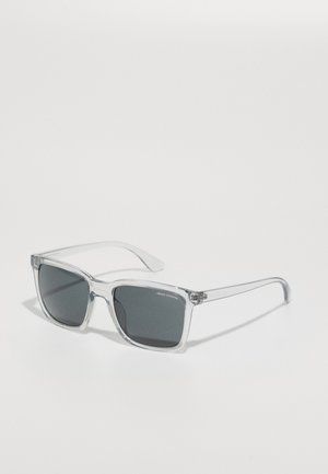 Transparente Rahmen-Sonnenbrille mit quadratischen Gläsern, graugefärbten Gläsern und dezentem Branding auf dem oberen linken Glas. Flexible Bügel.