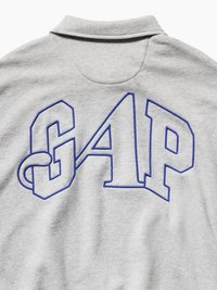 Γκρι φούτερ με γιακά που διαθέτει μεγάλα μπλε γράμματα "GAP" κεντημένα στο πάνω μέρος της πλάτης.
