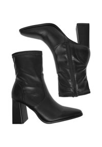 Czarne skórzane botki za kostkę z ostrymi noskami, bocznymi zamkami i grubymi obcasami, przedstawione pod kątem bocznym i od spodu.