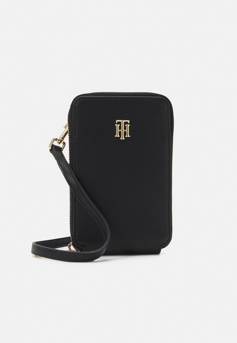 Musta rakenteinen käsilaukku, joka on tehty teksturoidusta materiaalista. Siinä on kultainen logokoriste ja irrotettava olkahihna helppoon kantamiseen.