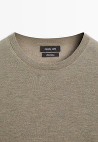 Olivgrön kashmirtröja med rund halsringning och en jämn textur. Inuti finns etiketter med "Massimo Dutti" och skötselråd.