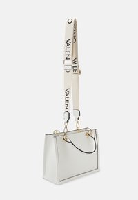 White handbag with black trim, rectangular shape, gold hardware, and a detachable beige strap featuring "VALENTINO" in black lettering.
