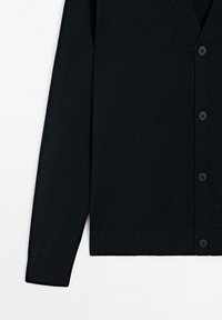 Mörkblå cardigan med v-ringning, ribbade muddar och avslut. Har sex svarta knappar fram, tillverkad av ett mjukt stickat material.
