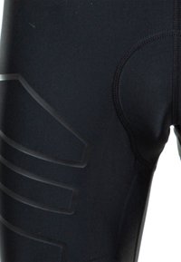Schwarze sportliche Leggings mit strukturierten Akzenten und einem hohen Taillenbund, aus dehnbarem Material für Komfort und Bewegungsfreiheit.