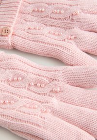 Rosa gestrickte Handschuhe mit einem Kabeldesign, dekorativen Perlenakzenten und einem herzförmigen Knopf am Handgelenk. Weicher Stoff und leicht.