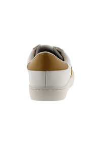 Baskets blanches avec un dessus en cuir lisse, accent jaune sur le talon et doublure grise texturée. Elles disposent d'une semelle en caoutchouc et de coutures minimales.