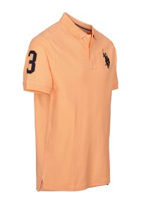 Rövid ujjú, világos narancssárga pamut póló, fekete logóval a mellkason és fekete "3" számmal az ujján.