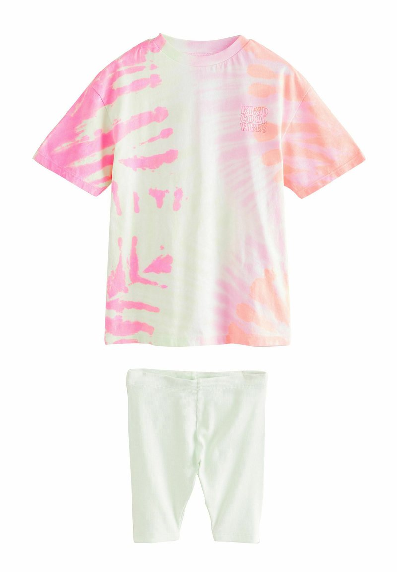 Koszulka z tie-dye w pastelowych odcieniach różu i zieleni, z krótkimi rękawami oraz napisem "Kind Cool Vibes"; zestawiona z jasnoszarymi legginsami.