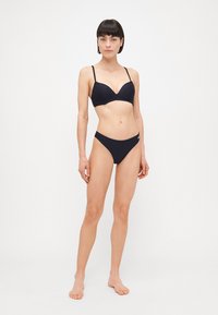 Bikini set u tamnoplavoj boji koji se sastoji od podstavljene bikini grudnjake s podesivim trakama i odgovarajućim niskim gaćicama, izrađenog od glatkog materijala.