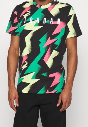T-shirt noir à manches courtes avec des motifs audacieux d'éclairs en néon vert, rose et jaune, et le texte "JORDAN" inscrit sur la poitrine.
