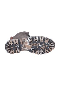 Braune Wildlederstiefel mit einer strukturierten Sohle, die mit schwarzen Gummi-Traktionsnägeln und einem gesprenkelten braunen Design versehen ist. Verstärkter Absatz für Langlebigkeit.