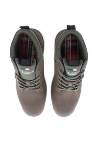 Par av bruna U.S. Polo Assn. snörskor för vardagsanvändning med gröna stoppade kragar och rutigt innerfoder, visade uppifrån.