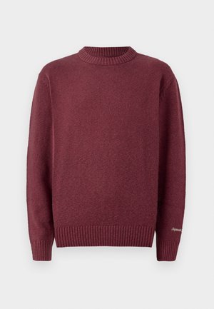 Burgundy knitted sweater with a ribbed crew neckline and cuffs. Soft texture, featuring a small embroidered detail on the sleeve.