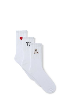 Tre paia di calze bianche con design ricamati: un cuore rosso, un nastro nero e un orsetto marrone. Tessuto misto cotone, polsini a coste.