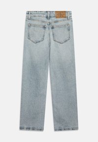 Lyse blå denimjeans, vanlig passform, med et lærmerke på baklivet og to baklommer. Klassisk design med rette ben.