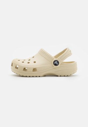 Beige Clogs aus leichtem, strapazierfähigem Material. Mit seitlichen Belüftungslöchern, einer strukturierten Sohle und einem Rückenriemen für einen sicheren Sitz.