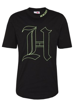 Black cotton t-shirt featuring a large neon green letter "H" in a bold font style, with "MCMLXXI" embroidered on the collar.
