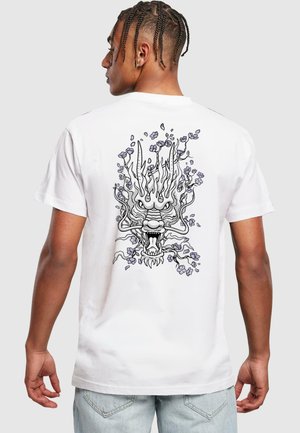 T-shirt en coton blanc avec un motif de dragon entouré de vignes et de fleurs violettes au dos, col rond et manches courtes.