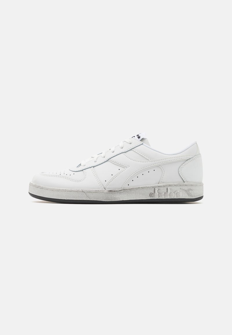 White leather sneaker featuring perforated details, round toe, flat laces, and a slightly textured gray midsole with brand logo.