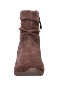 Botín de ante marrón con cuello holgado, cremallera lateral y punta redondeada. Textura suave y suela plana de goma.