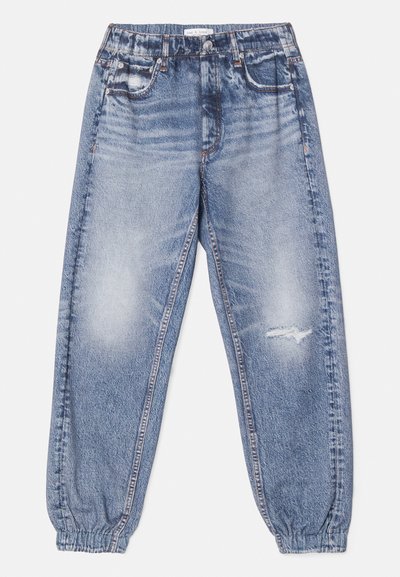 Ανοιχτό μπλε τζιν παντελόνια joggers με ελαστική μέση, συρρικνωμένα μπατζάκια και φθαρμένα σημεία κοντά στα γόνατα. Μαλακή, ξεθωριασμένη υφή με πλαϊνές τσέπες.