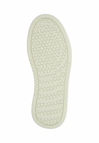 Valkoinen kumipohjainen kengänpohja, jossa on kuusikulmaisia ja pyöreitä urituksia pidon parantamiseksi, kuvattuna alapuolelta valkoisella taustalla.