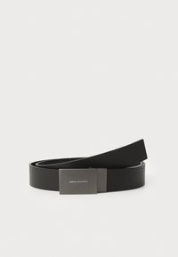 Cinturón de cuero negro con textura suave, que cuenta con una hebilla rectangular de tono plateado con logo grabado, que se estrecha hacia el final.