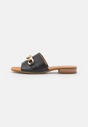 Sort åben tå slide-sandal med lavt træhæl og guldkæde-detalje på bred læderrem.