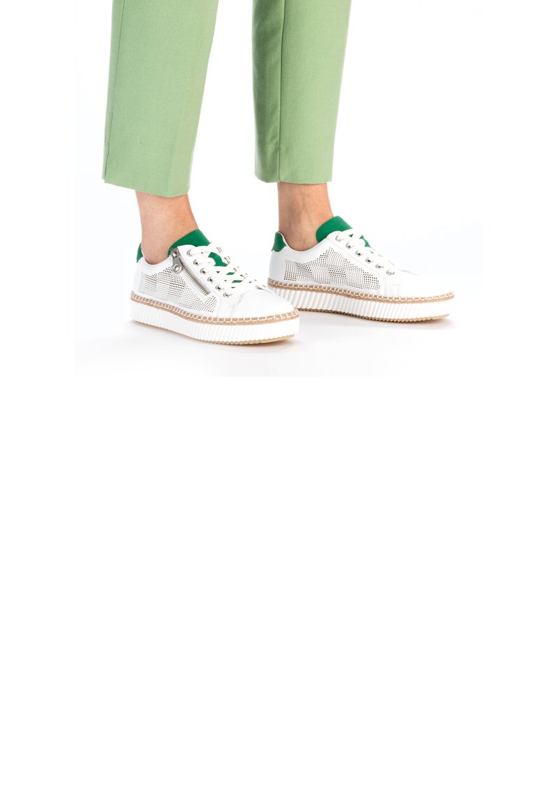 Baskets blanches avec des accents verts, dotées de panneaux en maille, d'une fermeture éclair sur le côté et d'une semelle texturée avec des détails tressés. Associe avec un pantalon vert.