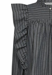 Blusa grigia a righe con strisce verticali nere, dettagli arricciati sulle spalle e chiusura a bottoni sul collo. Tessuto leggero.