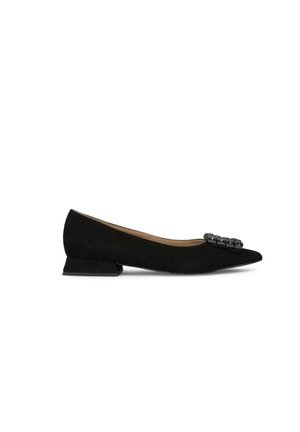 Flat shoe in suede nero con punta affusolata, caratterizzata da un'accensione decorativa in metallo nella parte anteriore e un tacco basso a blocco.