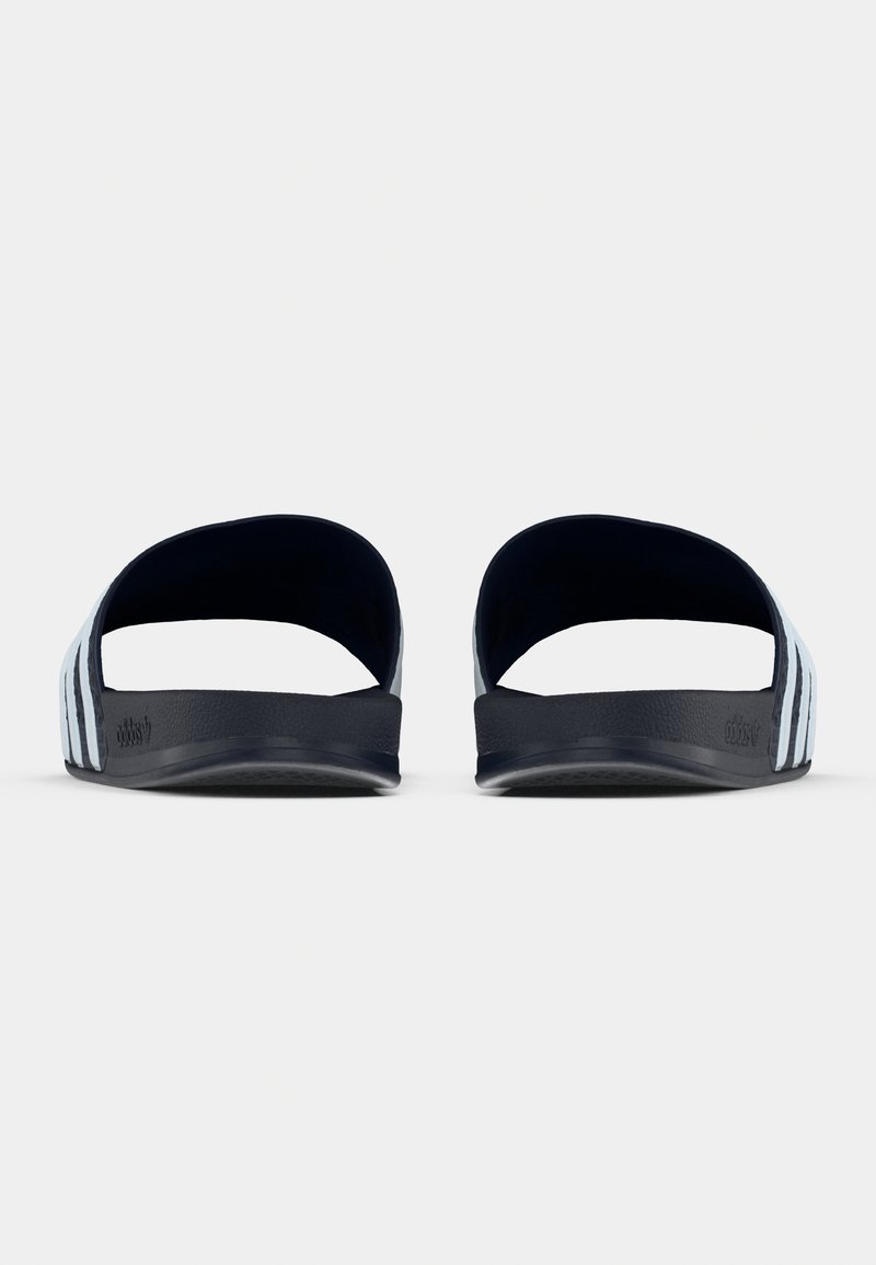 Sorte gummisandaler med åbent bagstykke, med tre hvide striber på hver side og en tekstureret sål for bedre greb.