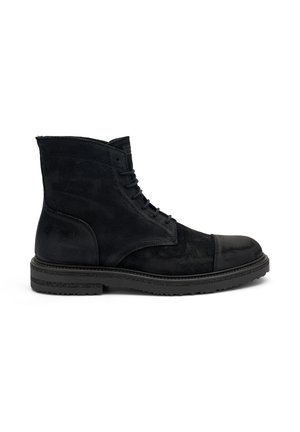 Bottine en daim noir à lacets, avec un bout rond, une semelle en caoutchouc et une tige texturée. Présente des détails de couture et un talon renforcé.