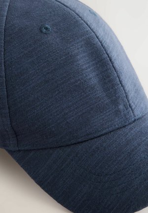 Gorra de algodón azul marino con una textura suave, diseño estructurado y un pico redondeado. Presenta un patrón cosido y un botón en la parte superior.