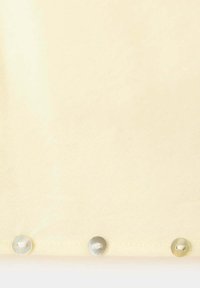 Tela beige clara con tres botones translúcidos distribuidos uniformemente en el borde inferior, cosidos con hilo blanco.