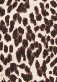 Leopardenmusterstoff mit dunkelbraunen und schwarzen Flecken auf einem hellbeigen strukturierten Hintergrund. Glattes Strickmaterial mit einem subtilen Glanz.