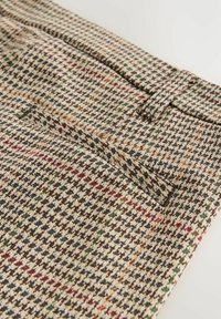 Houndstooth patterned trousers made from a textured fabric in beige, brown, and green, featuring a rear pocket and a belt loop.